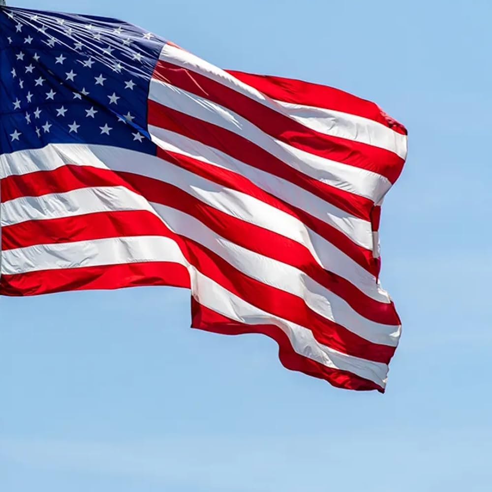 American flag against a blue sky background, waving in the wind