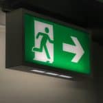 Emergency exit sign symbolizing the importance of planning escape routes in a family emergency plan.