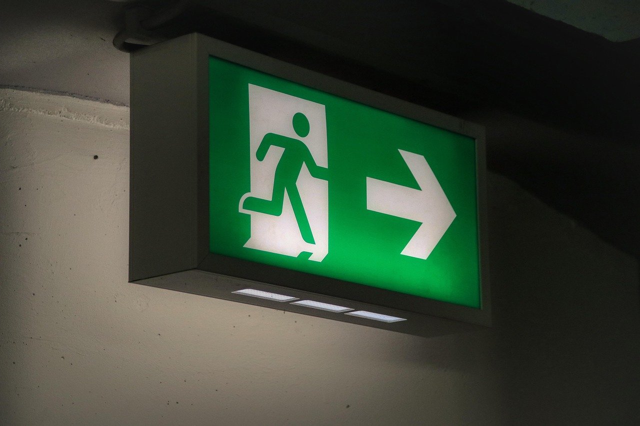 Emergency exit sign symbolizing the importance of planning escape routes in a family emergency plan.