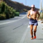 A physically fit man running outdoors as part of an emergency preparedness routine.