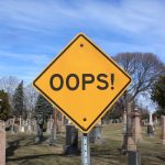 An "Oops!" sign in front of a graveyard, representing 10 Common Prepping Mistakes and How to Avoid Them