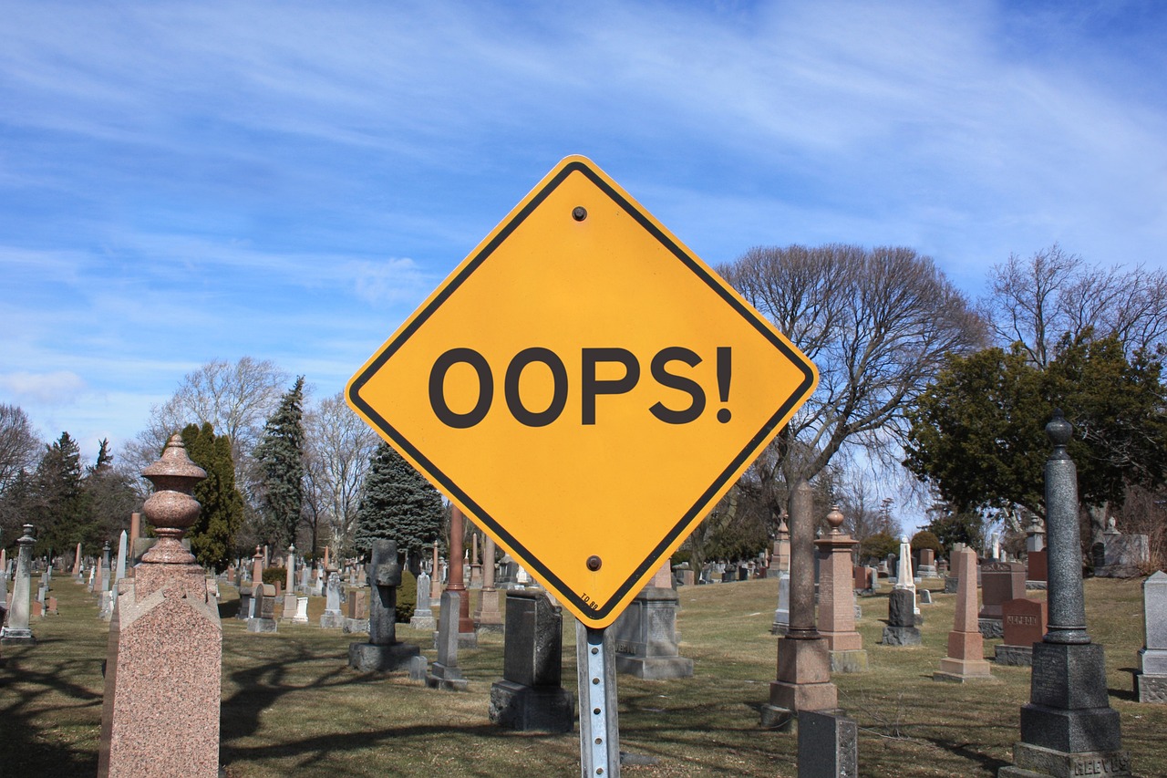 An "Oops!" sign in front of a graveyard, representing 10 Common Prepping Mistakes and How to Avoid Them