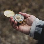 A hand holding a compass, representing Basic Navigation Skills