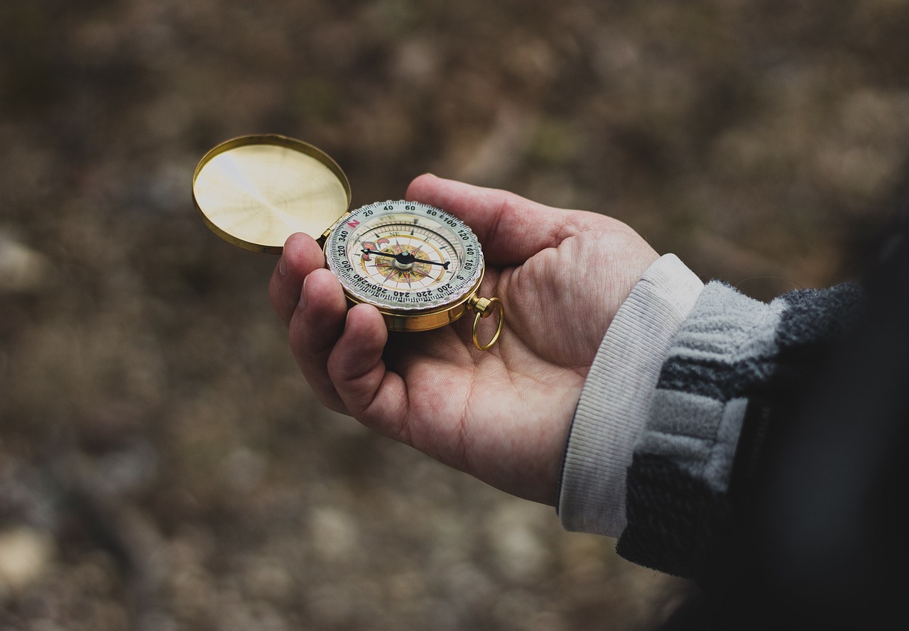 A hand holding a compass, representing Basic Navigation Skills