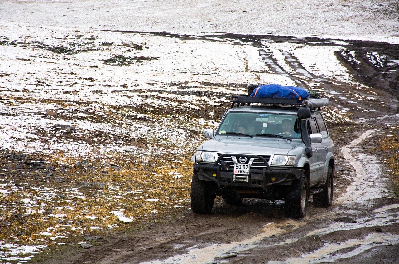 An SUV driving off-road with gear secured on top, representing the "Best Bug Out Vehicles"