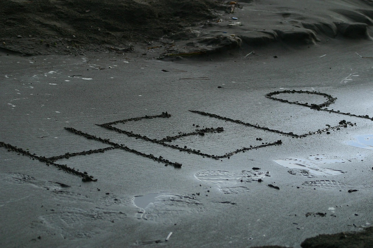 "HELP" written in the sand, representing Emergency Signaling