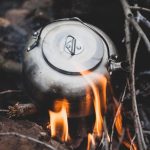 A camping kettle on an open fire, representing Purifying Water in an Emergency