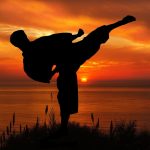 Sunset silhouette karate kick, representing Basic Self-Defense Techniques